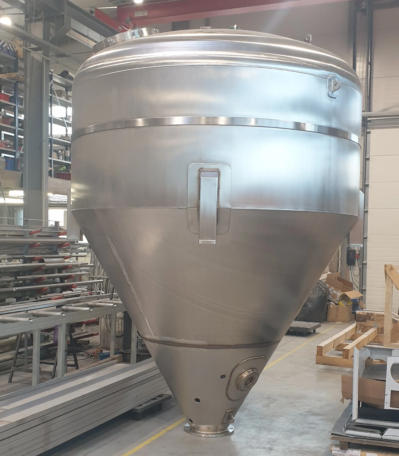 Przemysłowy zbiornik procesowy montowany w hali produkcyjnej podczas instalacji technologicznej Przemysłowy zbiornik procesowy montowany w hali produkcyjnej podczas instalacji technologicznej