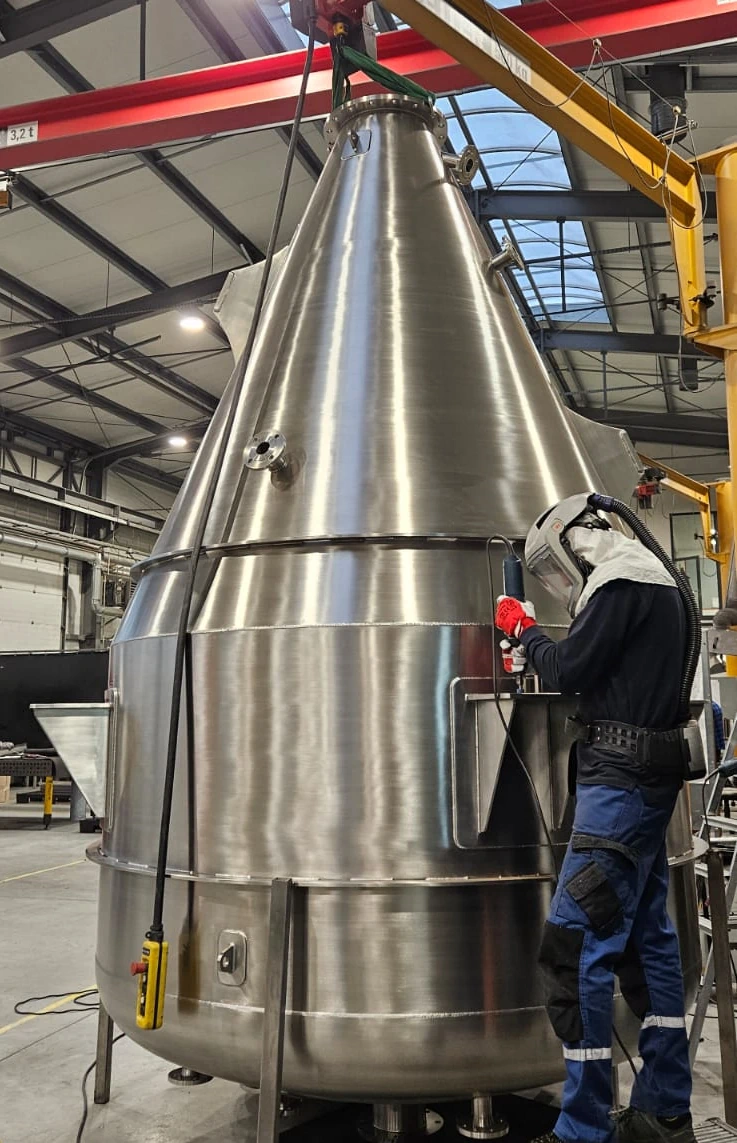 Instalacja zbiornika procesowego ze stali nierdzewnej inox w hali produkcyjnej podczas prac montażowych Instalacja zbiornika procesowego ze stali nierdzewnej inox w hali produkcyjnej podczas prac montażowych